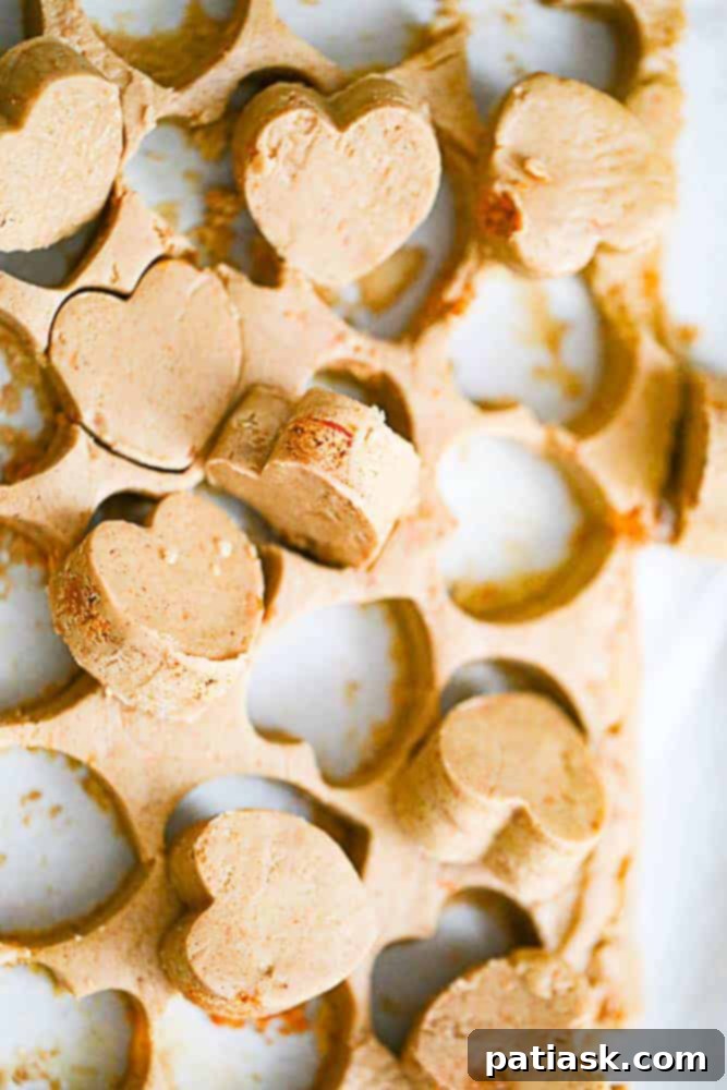 Golden Crisp Butterfinger Truffles 5 Heart-shaped Butterfinger truffles on a white plate, showcasing the chocolate and candy crumbles. Delicious and easy no-bake dessert.