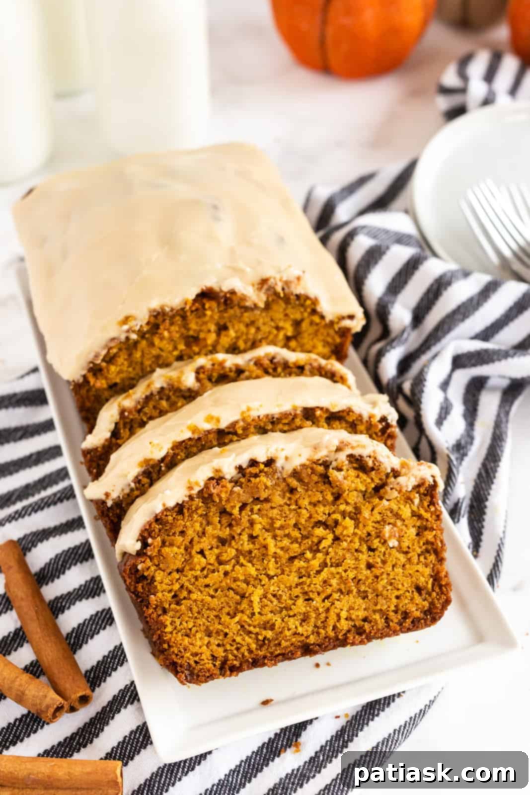 20 Pumpkin Bread Masterpieces for Autumn 4 A slice of moist pumpkin bread generously topped with a sweet maple glaze, ready to be enjoyed.