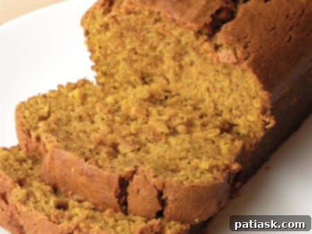 20 Pumpkin Bread Masterpieces for Autumn 5 A deeply colored, moist loaf of pumpkin bread, hinting at its rich flavor and perfect texture.