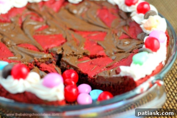 Velvet Heart Cookie Pie 3 Red Velvet Cookie Pizza topped with creamy strawberry buttercream and festive Valentine's Day candies.