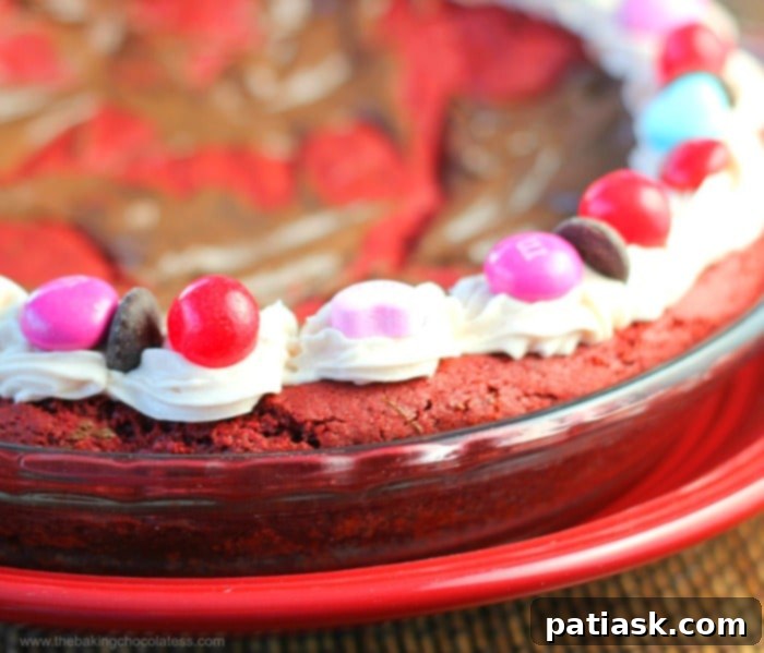 Velvet Heart Cookie Pie 4 Close-up of a festive Valentine Red Velvet Party Blast Cookie Pie, highlighting the Nutella swirls and candy decorations.