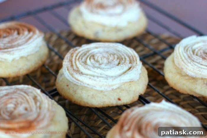 Close-up of Cream Cheese Frosted Cinnamon Bun Cookies on a cooling rack.