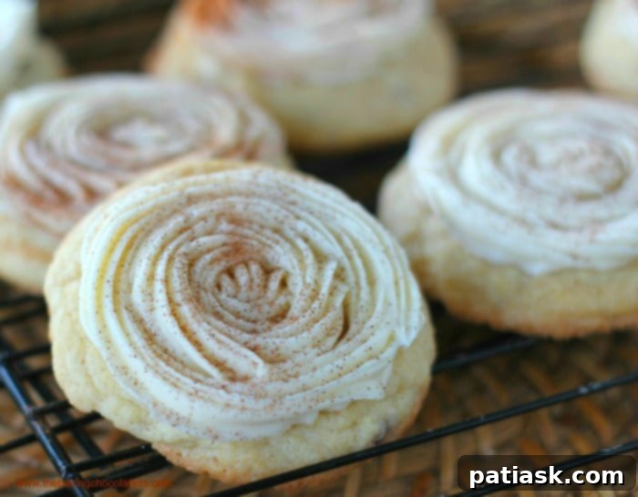 A stack of Cream Cheese Frosted Cinnamon Bun Cookies on a wooden board.