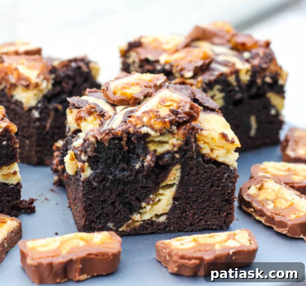 Decadent Kahlua Cheesecake Snickers Brownies recipe, showcasing layers of fudgy brownie, creamy cheesecake, and chunks of Snickers