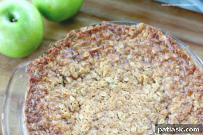 A slice of Swedish Apple Pie on a plate with ice cream