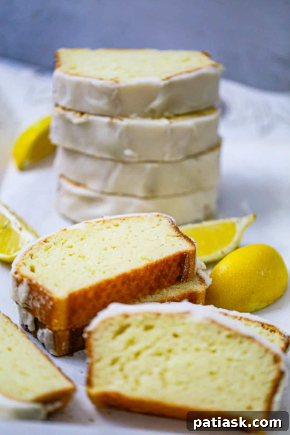 Starbucks-Inspired Glazed Lemon Loaf 5 Lemon Loaf recipe - A rustic shot of the lemon loaf on a cutting board with lemon slices.