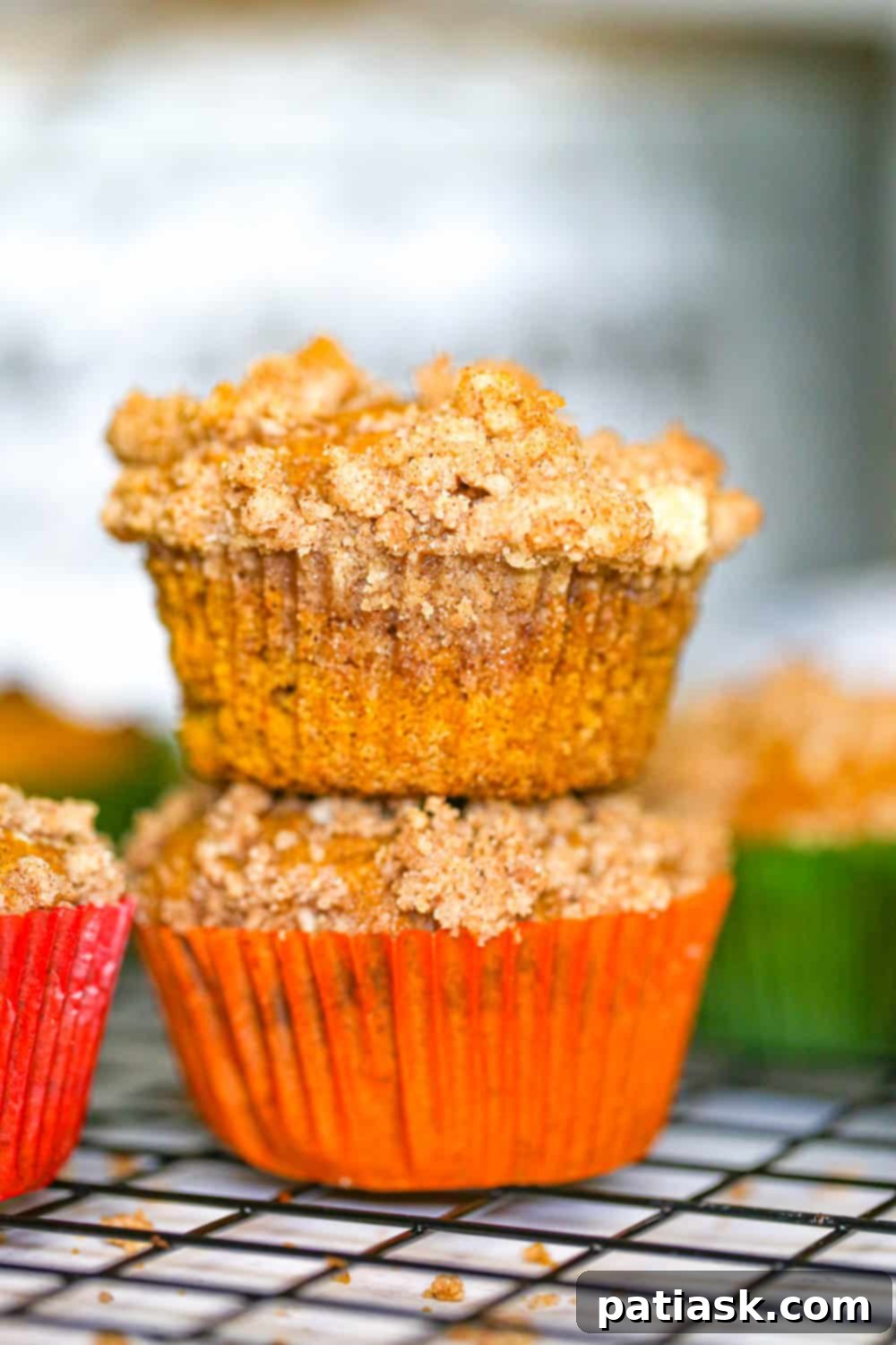 Spiced Pumpkin Crumble Muffins 4 Close-up of golden-brown pumpkin streusel muffins cooling on a wire rack, showing their appealing texture.
