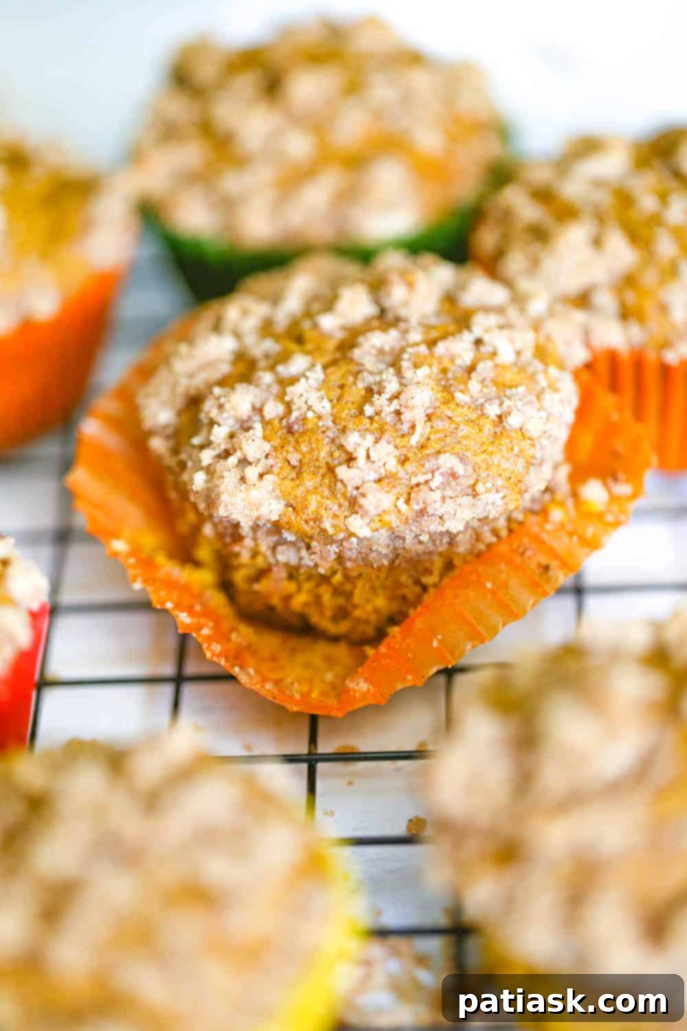 Spiced Pumpkin Crumble Muffins 5 A beautiful array of freshly baked pumpkin streusel muffins, highlighting their fluffy tops and generous crumb topping.