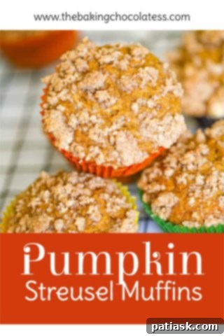 Spiced Pumpkin Crumble Muffins 9 Three perfectly baked pumpkin streusel muffins on a rustic wooden board, ready for serving.