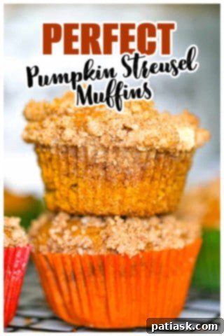 Spiced Pumpkin Crumble Muffins 13 A warm, freshly baked pumpkin streusel muffin, still in its paper liner, highlighting its soft interior.