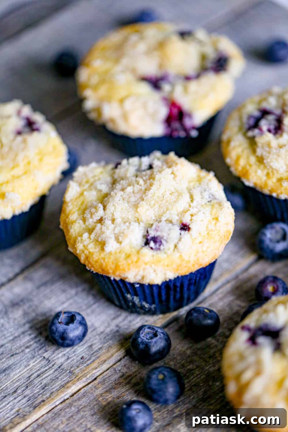 Decadent Blueberry Cream Cheese Muffins 2 Blueberry Cream Cheese Muffins - A close-up of a stack of freshly baked muffins.