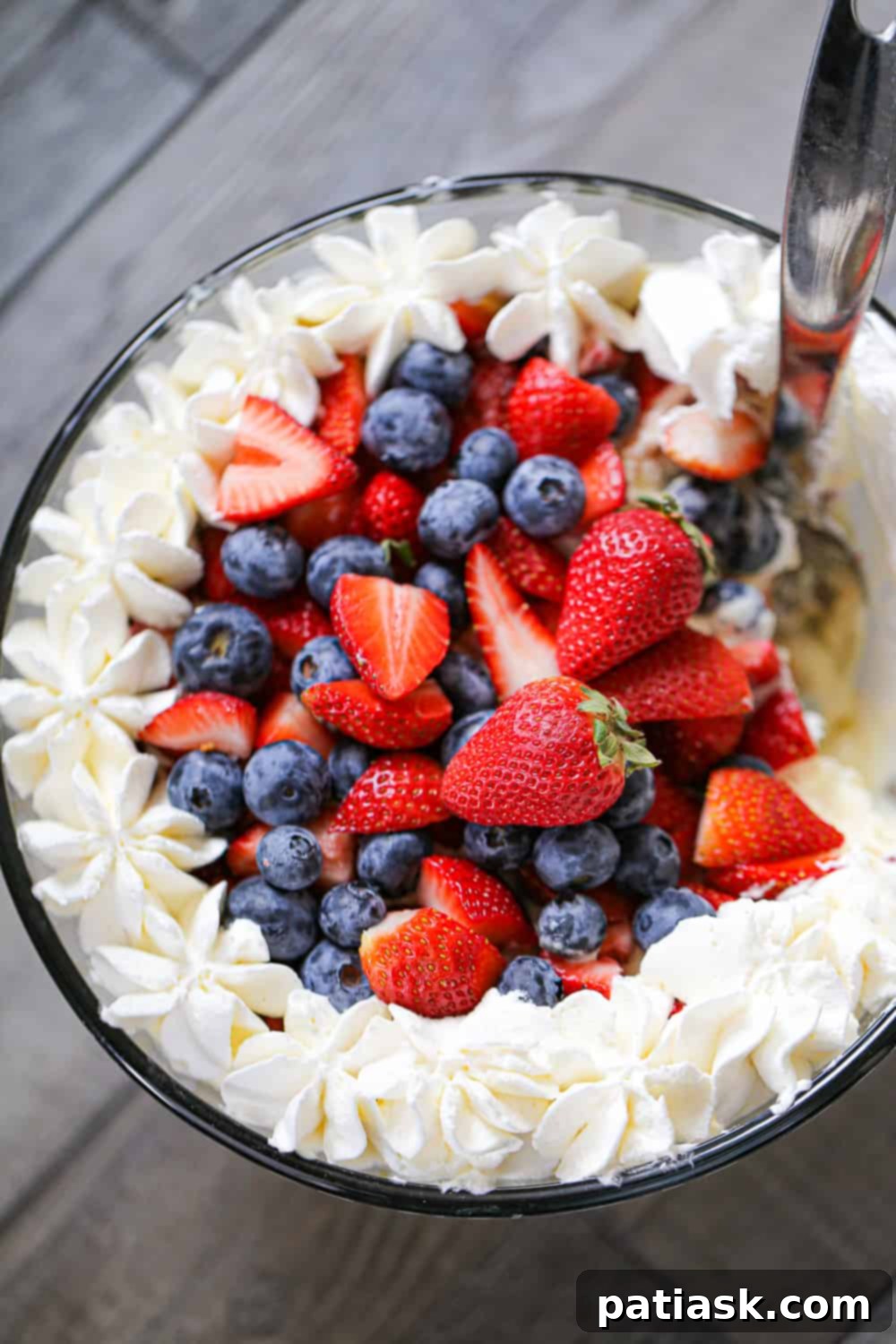 Close-up of a berry trifle showing the distinct layers of cake, berries, and cream, beautifully presented.