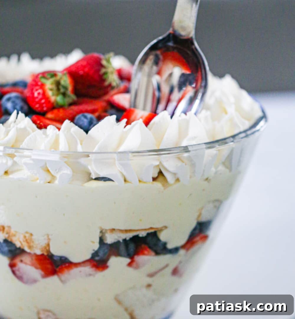 Individual serving of berry trifle in a glass, showcasing distinct layers of cake, fruit, and cream.