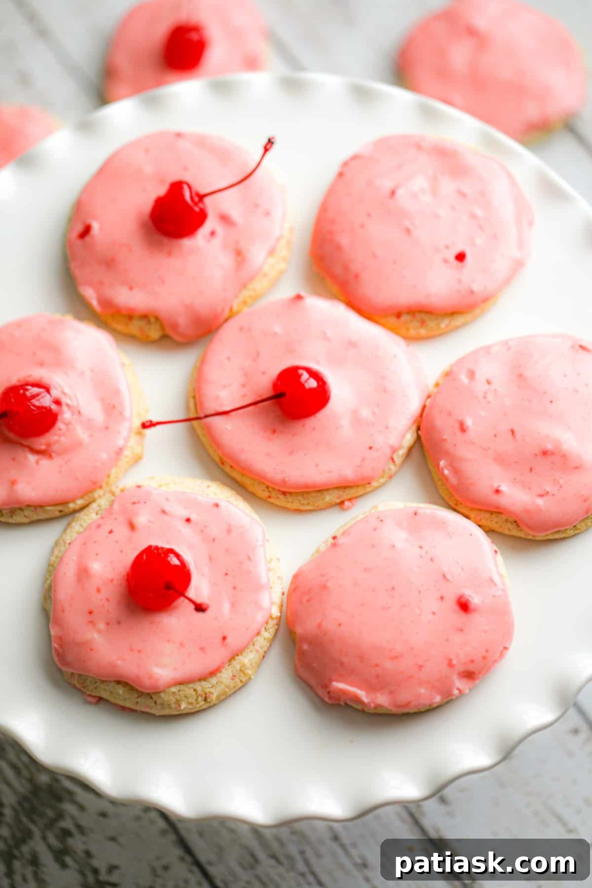 Sweet Cherry Chip Cookies 2 Soft and chewy Cherry Chip Cookies with a pink maraschino cherry glaze arranged beautifully on a white plate