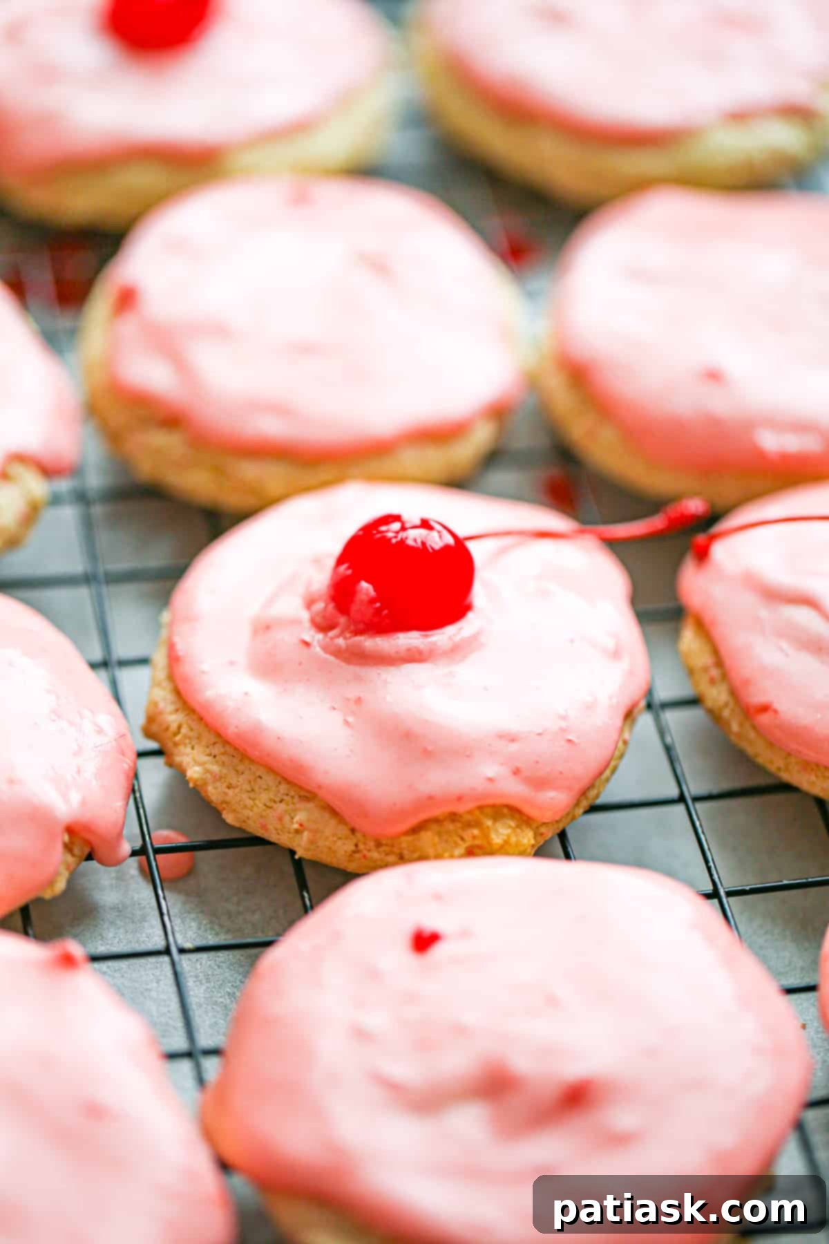 Sweet Cherry Chip Cookies 7 Unbaked Cherry Chip Cookie dough balls dotted with cherry pieces on a parchment-lined baking sheet, prepared for baking or freezing