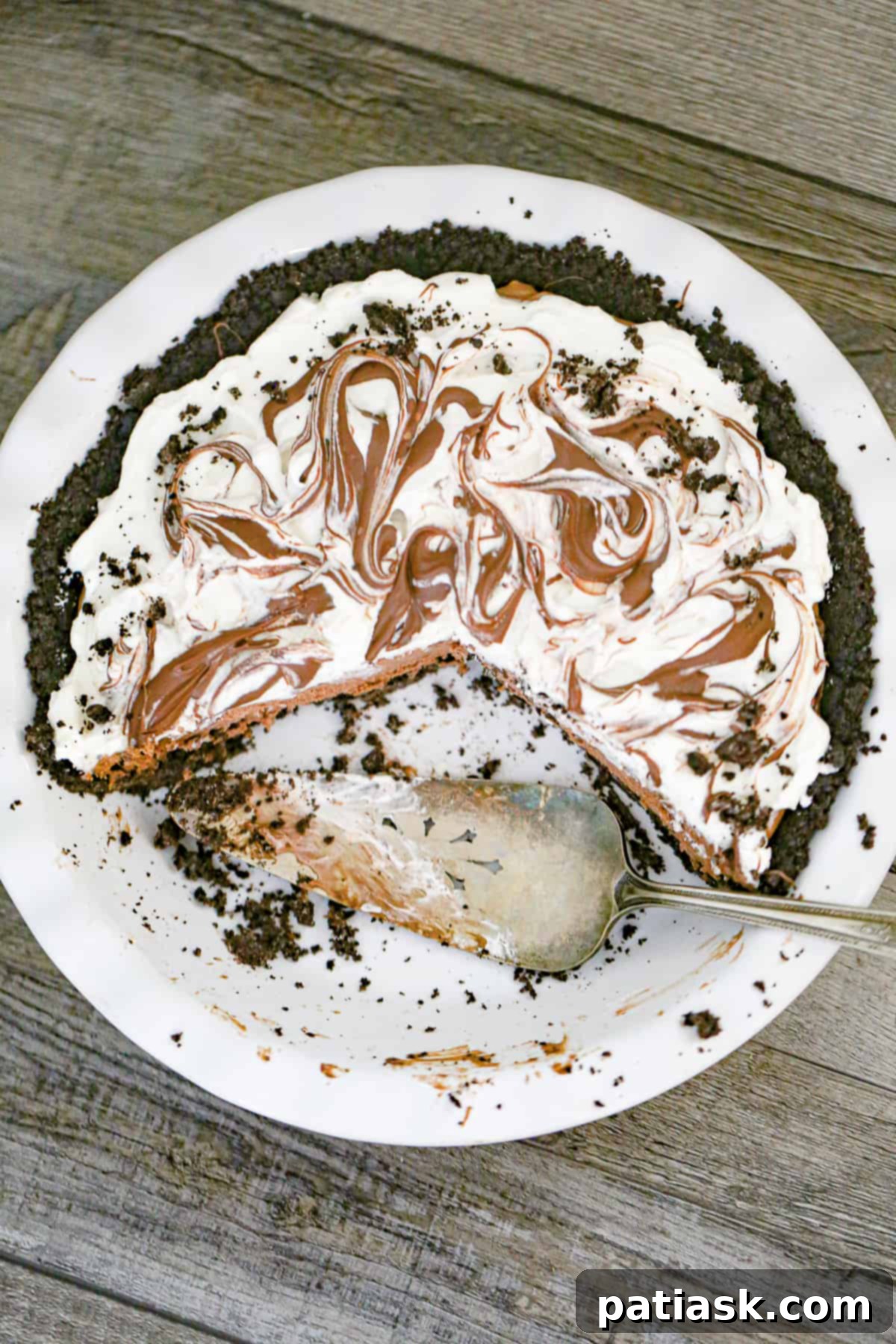 Full Nutella Cream Pie with whipped topping, ready to be sliced
