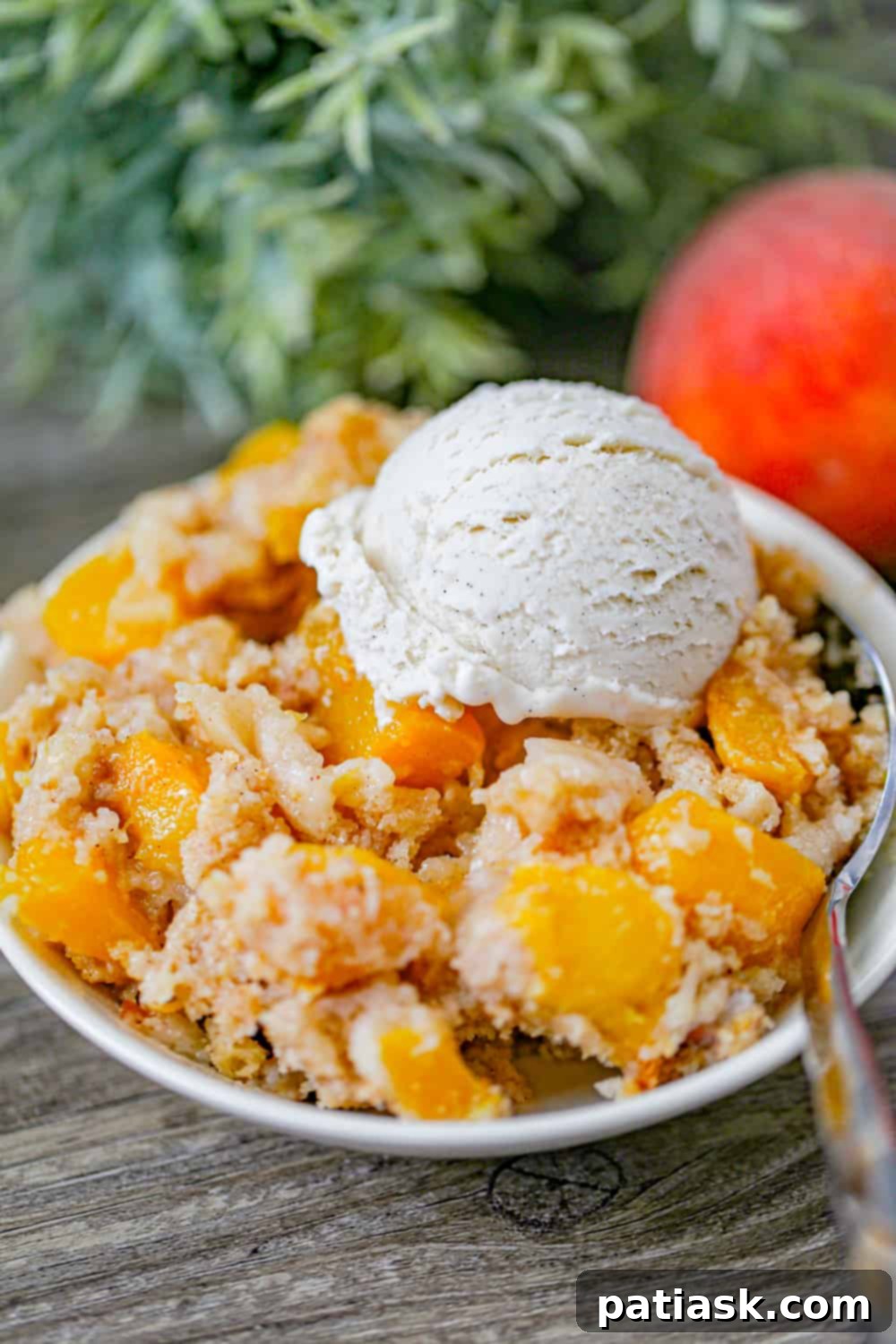 Effortless Peach Bake 2 Peach Dump Cake with ice cream in a bowl