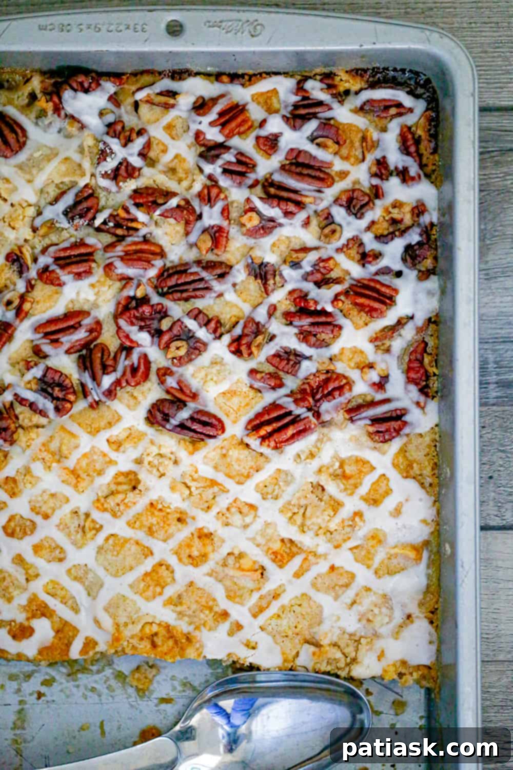 Effortless Peach Bake 3 peach dump cake in a pan with peaches, pecans and vanilla glaze