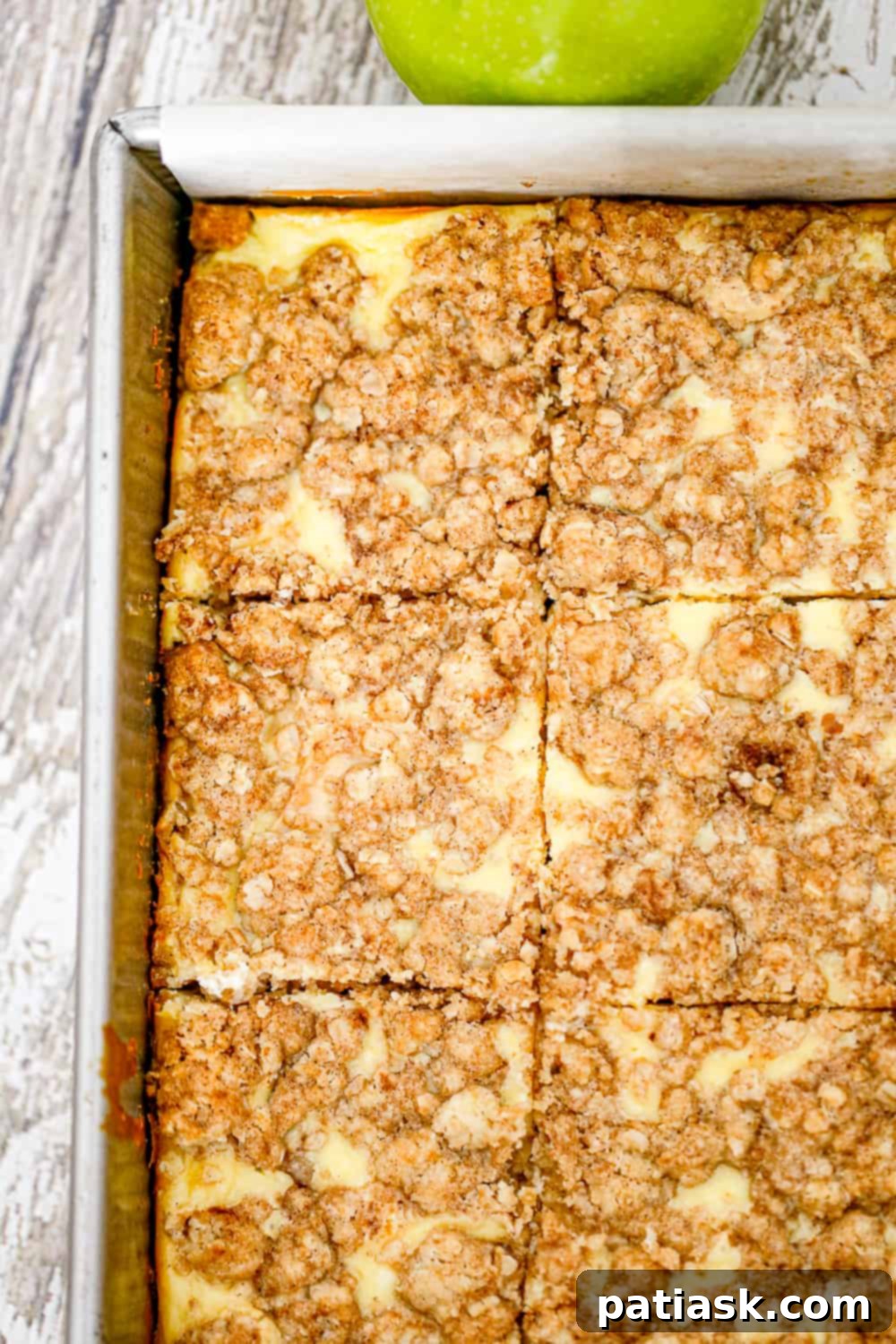 Autumn Apple Crumble Cheesecake Squares 4 Stacked apple cheesecake bars on a white plate