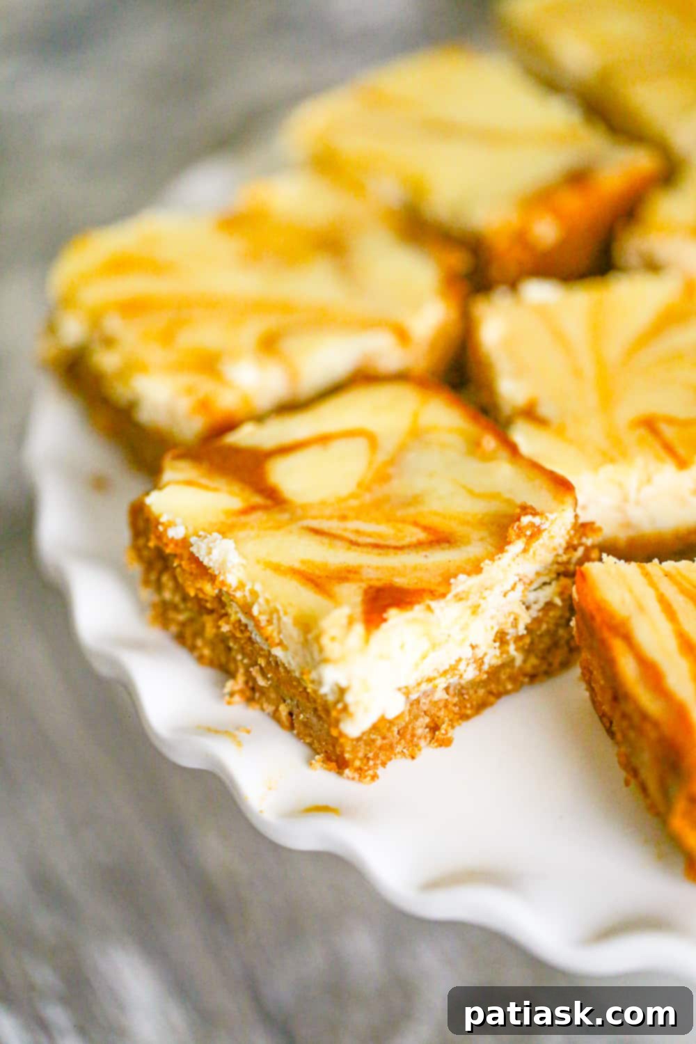 Effortless Pumpkin Cheesecake Bars 2 Delicious slice of easy Pumpkin Cheesecake Bar showcasing the creamy layers and graham cracker crust.