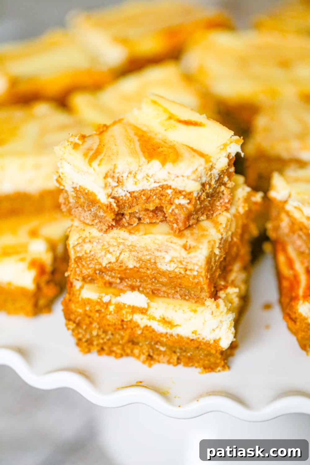 Effortless Pumpkin Cheesecake Bars 3 Stack of easy Pumpkin Cheesecake Bars on a plate, highlighting the delicious layers.