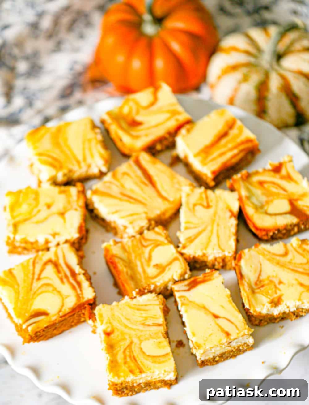 Effortless Pumpkin Cheesecake Bars 4 Fall-themed Pumpkin Cheesecake Bars arranged beautifully for a seasonal treat.