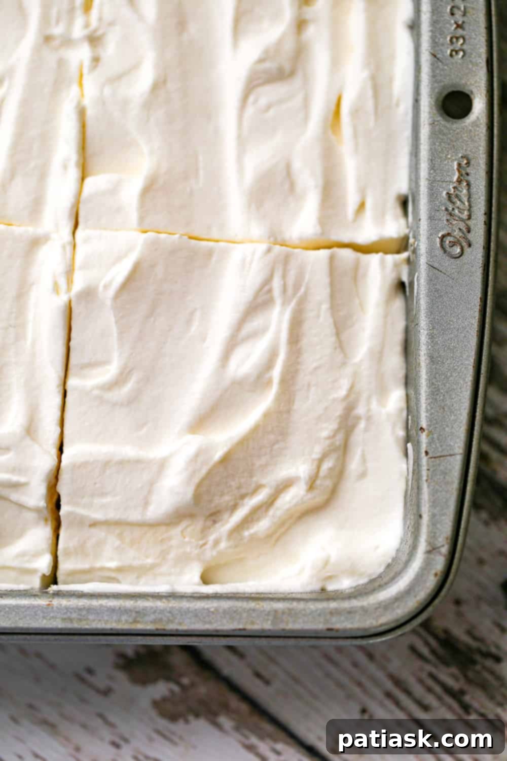 Slice of Vanilla Tres Leches Cake with delicate whipped cream
