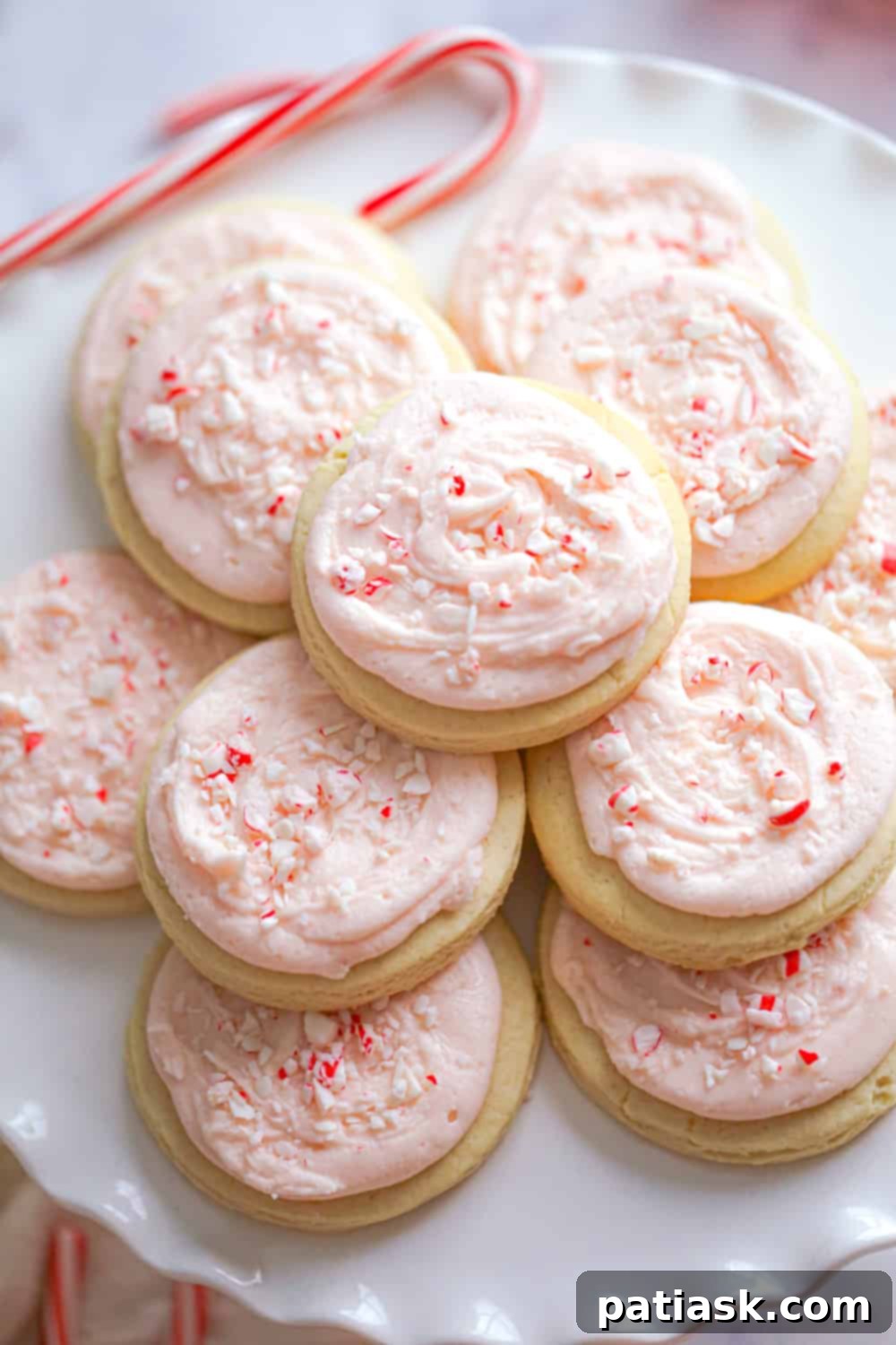 Peppermint Swirl Cookies 6 Plate of frosted candy cane cookies with red frosting and white crushed candy canes.