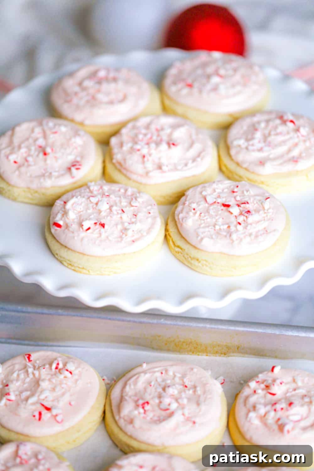 Peppermint Swirl Cookies 7 Another image of frosted candy cane cookies, showcasing the vibrant red frosting and crushed peppermint pieces.