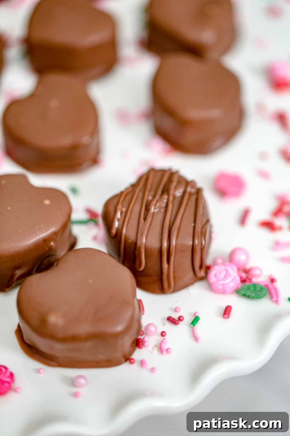 Two close-up images of Valentine's peanut butter hearts, one coated in milk chocolate and another in white chocolate