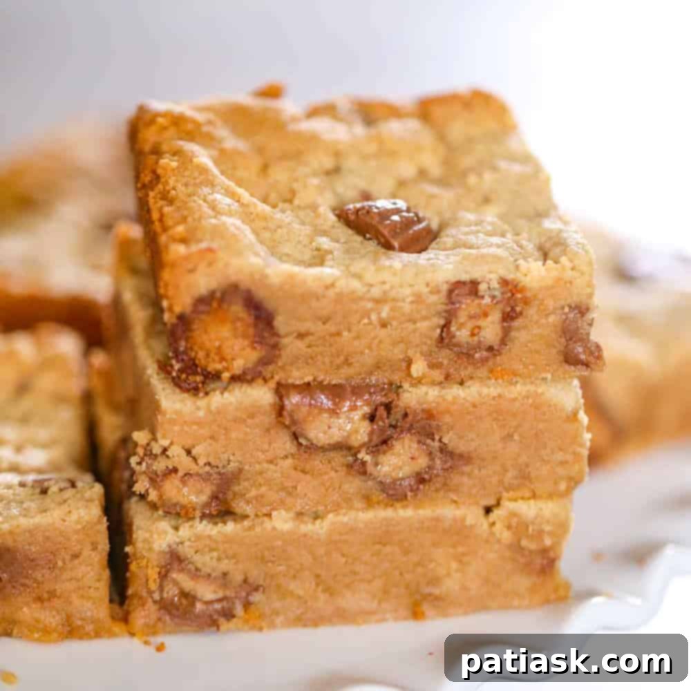 Irresistible Peanut Butter Cup Blondies 2 Stacked peanut butter blondies showcasing their gooey interior and peanut butter cups