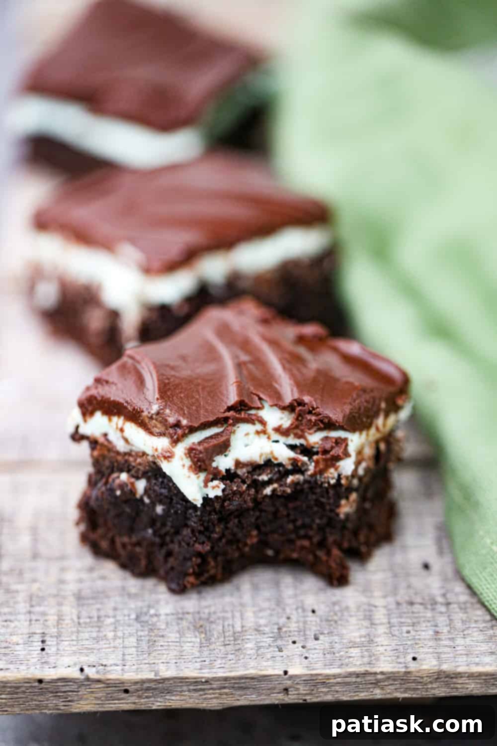 Cool Mint Chocolate Brownie Stack 2 Decadent Mint Chocolate Layered Brownies featuring fudgy chocolate, green mint, and dark ganache layers.