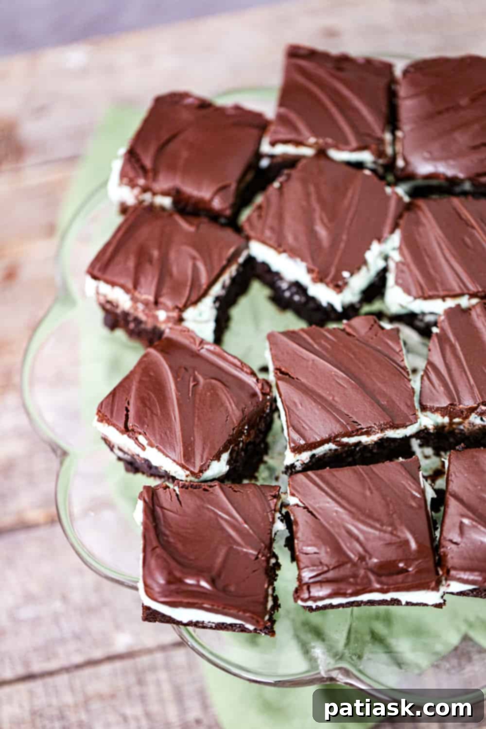 Cool Mint Chocolate Brownie Stack 3 Close-up of three layers of mint chocolate brownie, showcasing the rich chocolate brownie, green mint cream, and dark chocolate ganache.