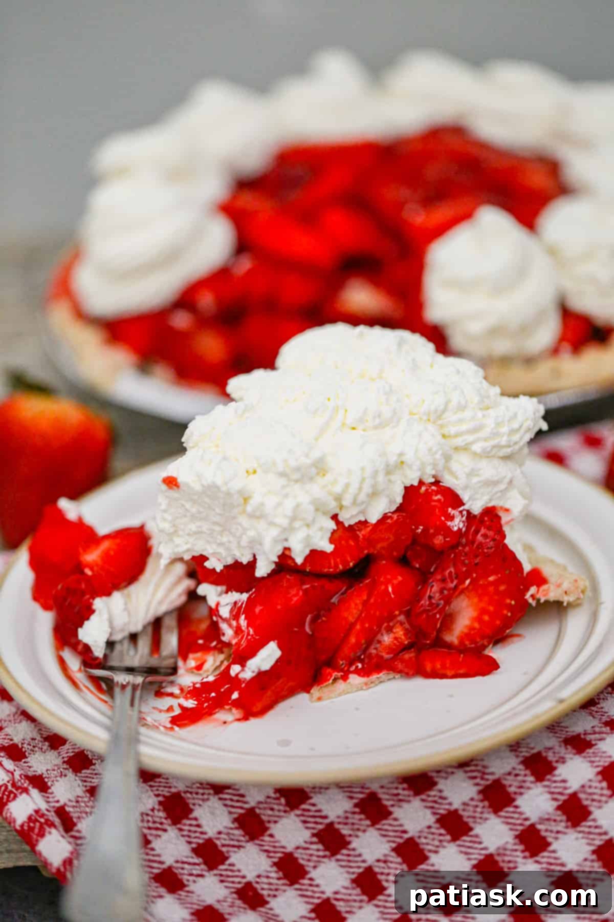 The Authentic Shoney's Strawberry Pie Copycat 4 A beautifully arranged fresh strawberry pie, glistening with glaze, surrounded by whole strawberries on a rustic wooden surface.
