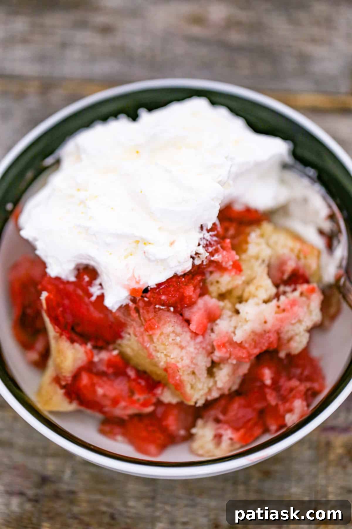 Best fresh easy homemade Strawberry Cobbler recipe in a bowl with whipped cream, ready to be enjoyed.