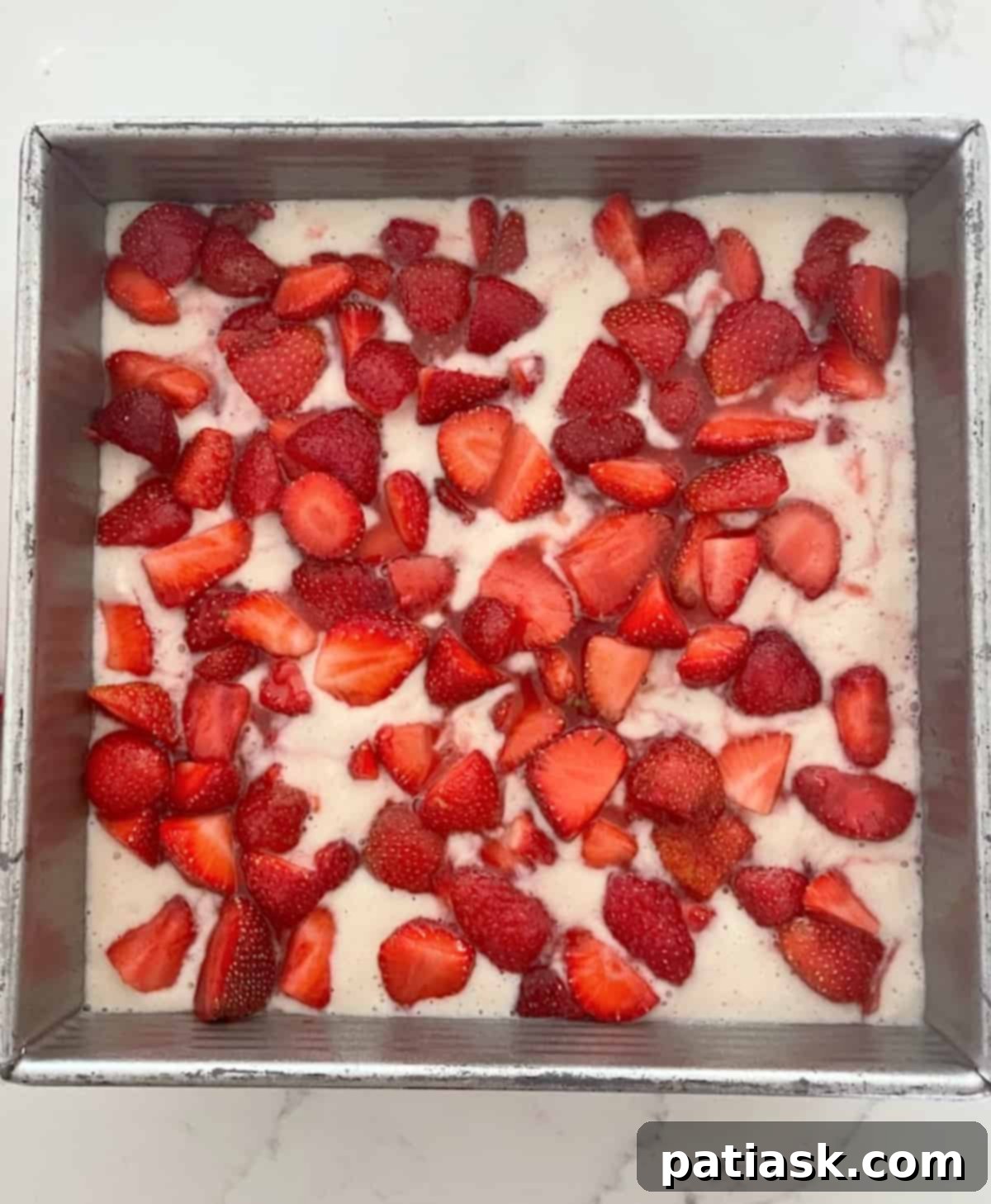 Best Fresh Strawberry Cobbler batter in the pan before baking, showing the distribution of ingredients.