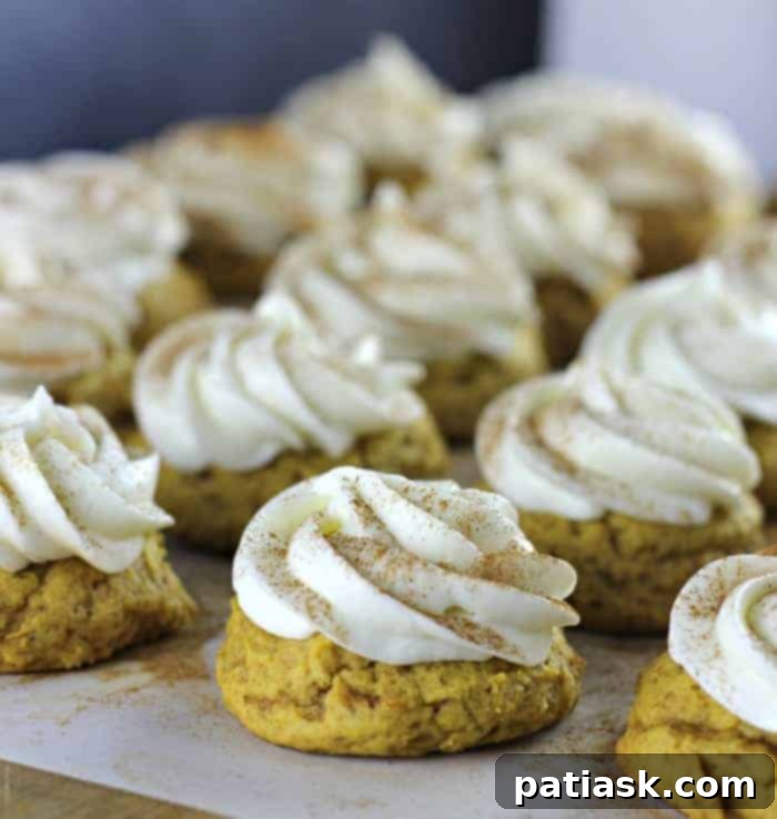 Melt-in-your-Mouth Ultimate Soft Pumpkin Cookies topped with a generous swirl of cream cheese frosting.
