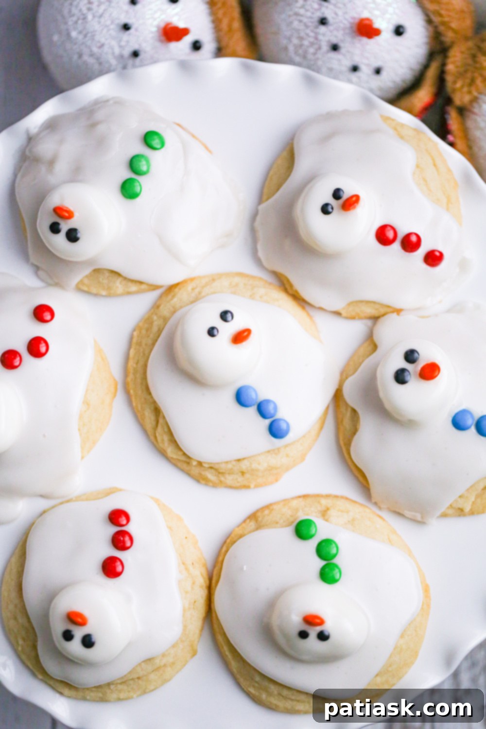 65 Festive Christmas Cookie Creations 17 Easy Melted Snowman Cookies with white frosting and candy decorations