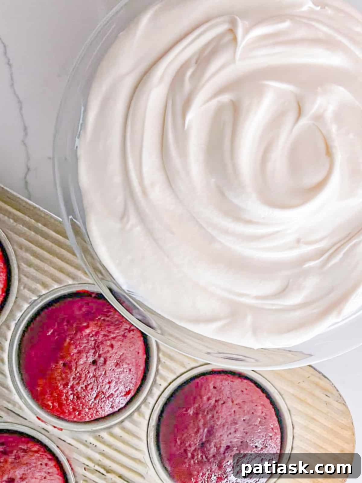 Platter of cupcakes generously frosted with creamy, tangy cream cheese frosting