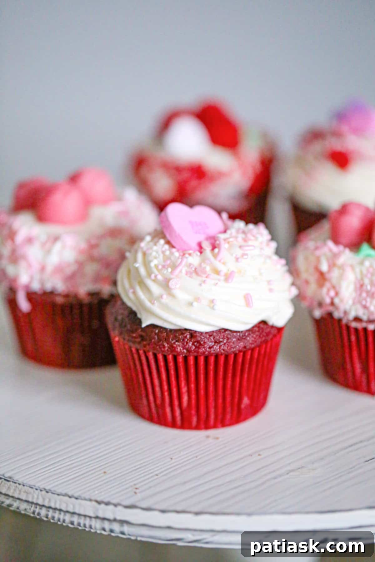 Festive cupcakes topped with cream cheese frosting and colorful candies for Valentine's Day