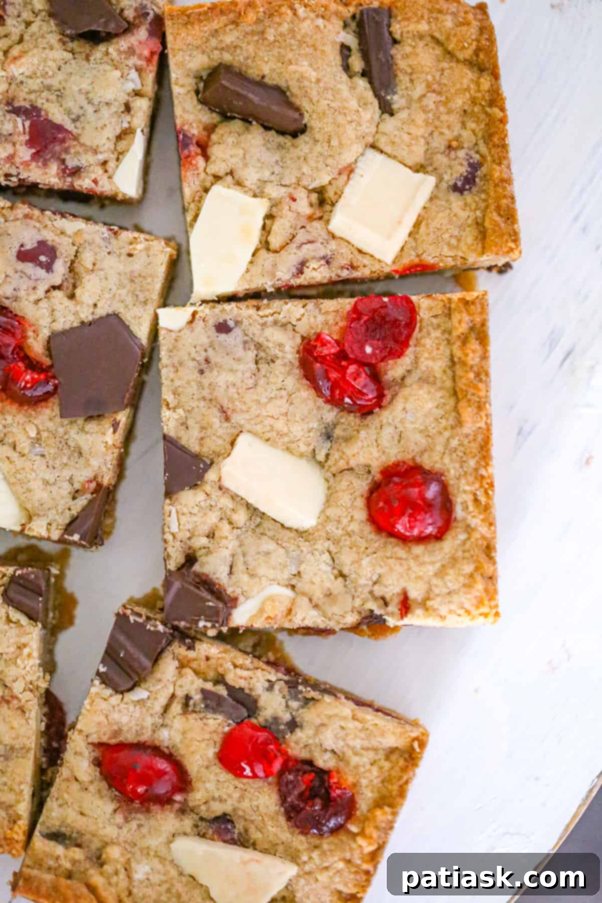 Peanut Butter Chocolate Cherry Bliss Bars 6 Peanut Butter Chocolate Cherry Bars with white chocolate and coconut on a plate