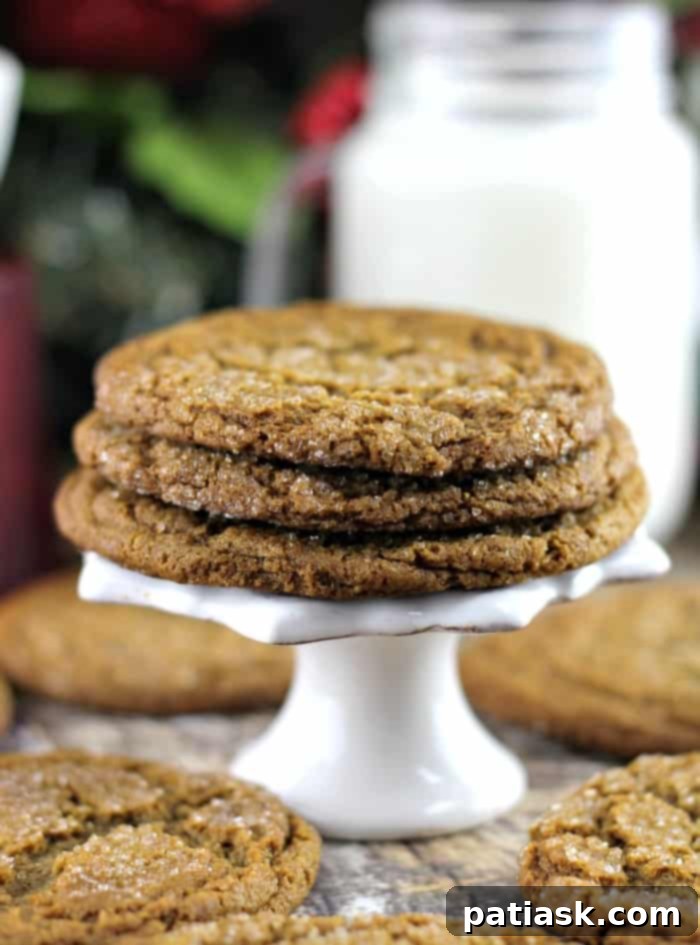 Soft and Chewy Ginger Molasses Cookies recipe stacked on a pedestal, perfect for holiday gatherings