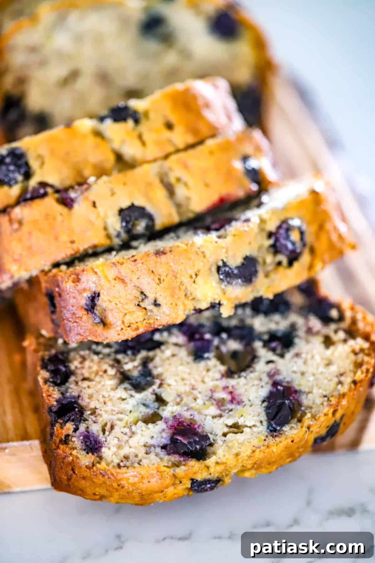 Effortless Blueberry Banana Bread 2 Easy Blueberry Banana Bread with a golden crust and blueberries visible.