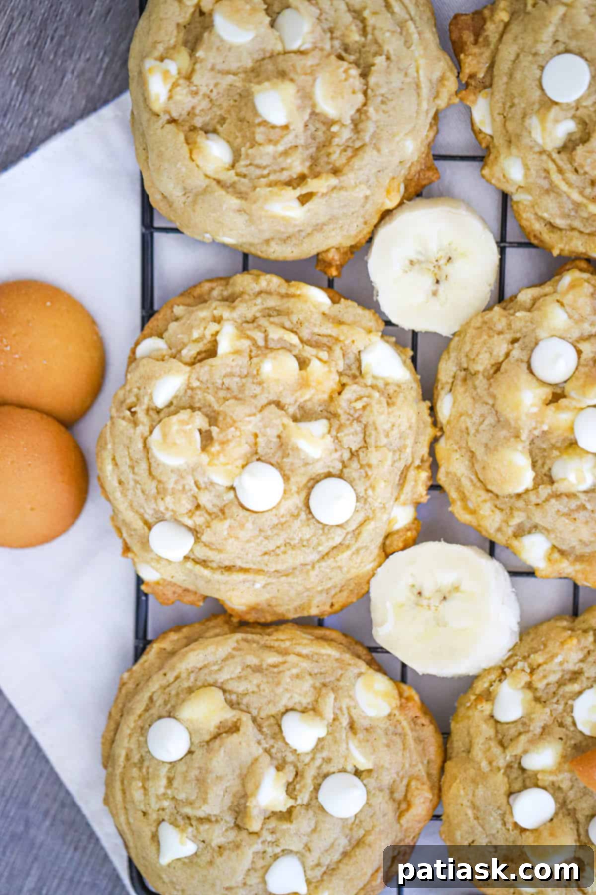 Delicious Banana Cream Pudding Cookies stacked high on a wooden board.