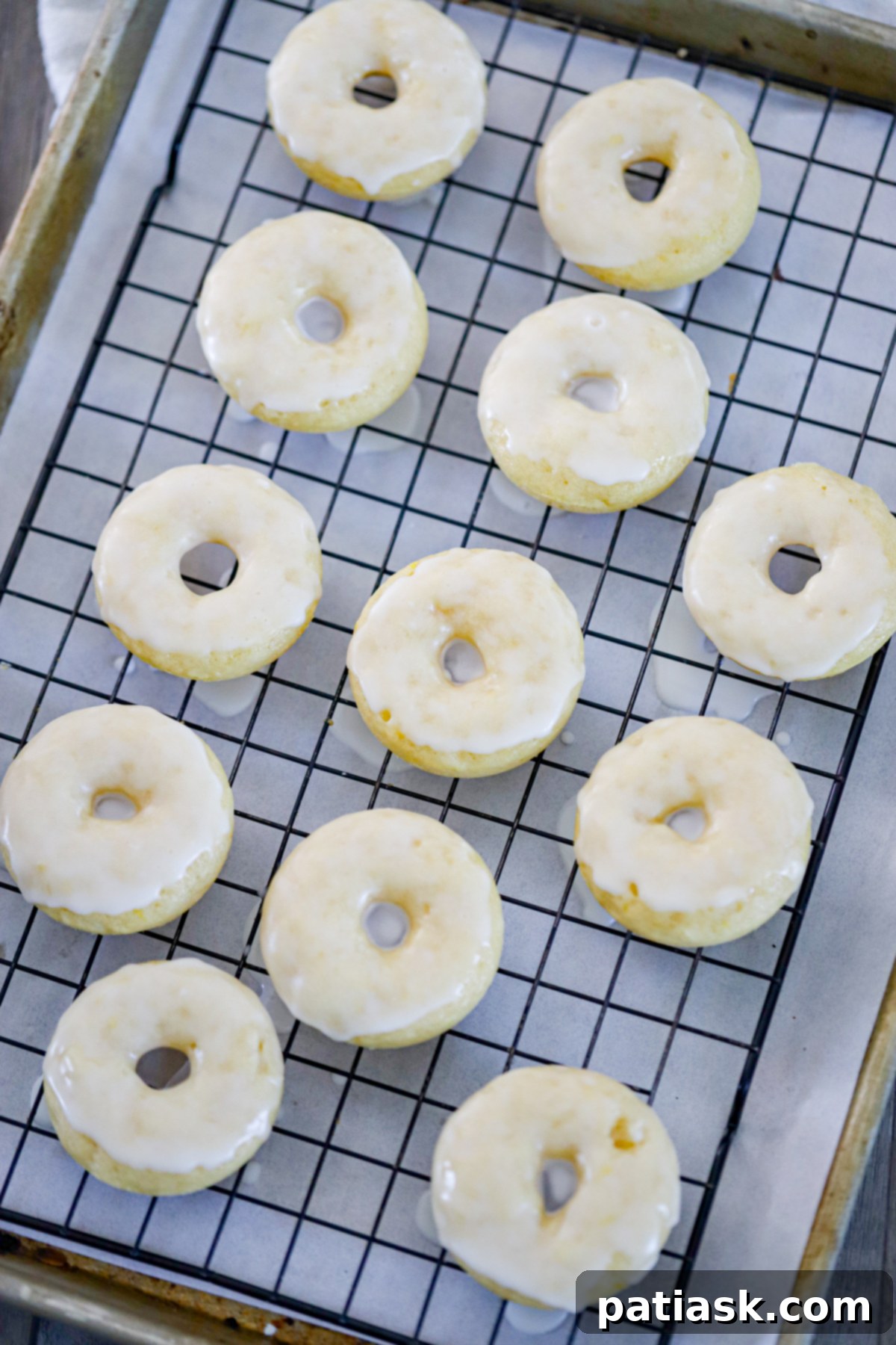 Lemon Zing Donuts 5 A baking tray filled with a fresh batch of golden baked lemon donuts, some glazed and others waiting for their zesty topping.
