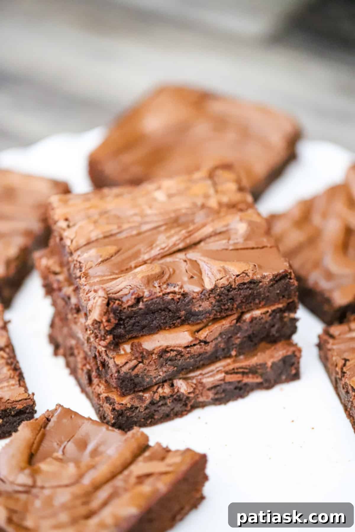 Decadent Nutella Swirl Brownies 4 Ingredients laid out for making Nutella brownies, including oil, cocoa, eggs, sugars, and a jar of Nutella.