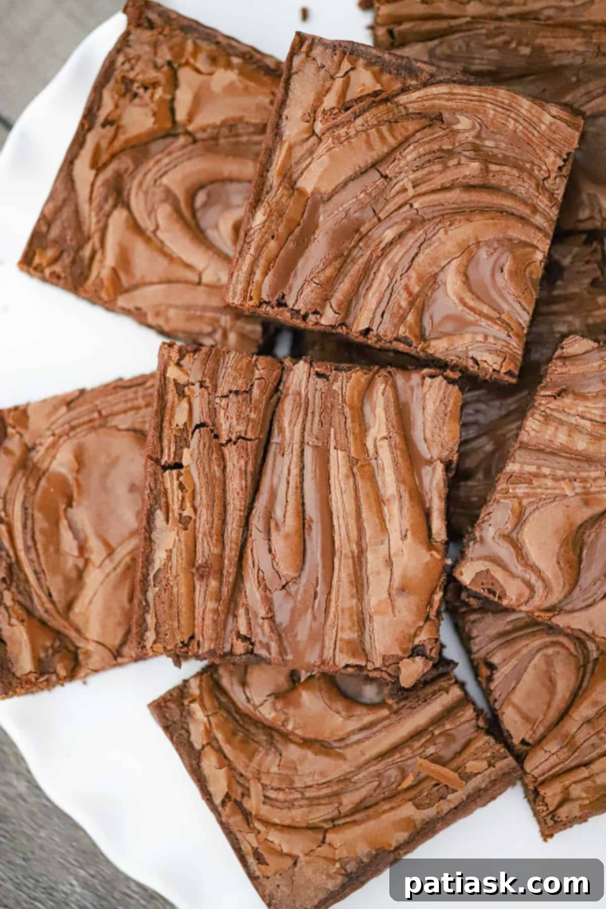Decadent Nutella Swirl Brownies 5 Perfectly cut Nutella brownies stacked on a plate, ready to be served.