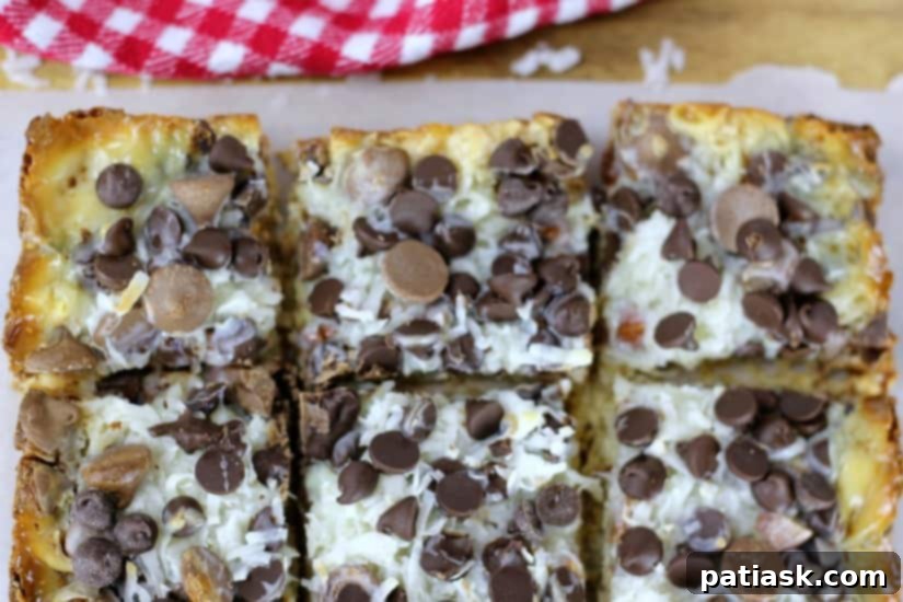 Almond Coconut Dream Bars 3 Stacked squares of Ultimate Almond Joy Magic Bars on a white plate