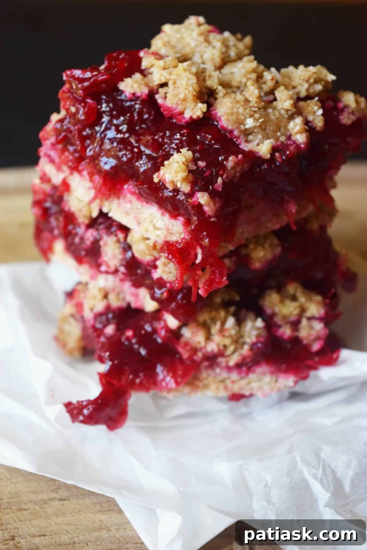 Several festive no-bake cranberry bars, showcasing their distinct layers and vibrant cranberry color.
