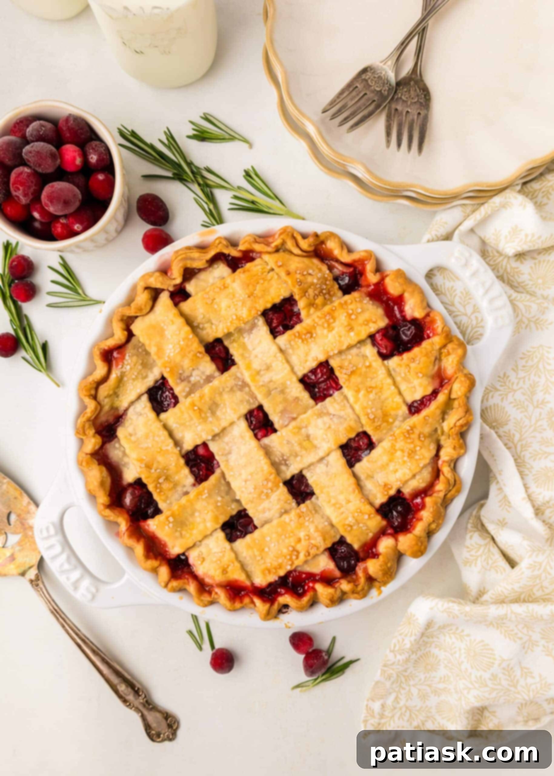 A perfectly baked vegan cranberry pie with a golden lattice top crust, showcasing the rich red cranberry filling beneath.
